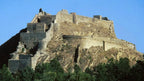 Ancient stone walls and towers of the historic Gori Fortress overlooking the city of Gori, Georgia.