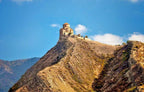 Side profile view of the ancient stone architecture of Jvari Monastery in Mtskheta.