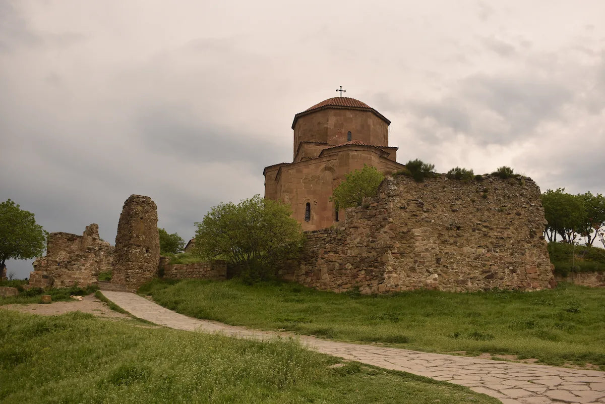 View of the historic Jvari Monastery stone building nestled in the Georgian landscape