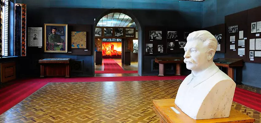 Interior of the Stalin Museum in Gori, featuring historical artifacts, portraits, and a bust of Joseph Stalin