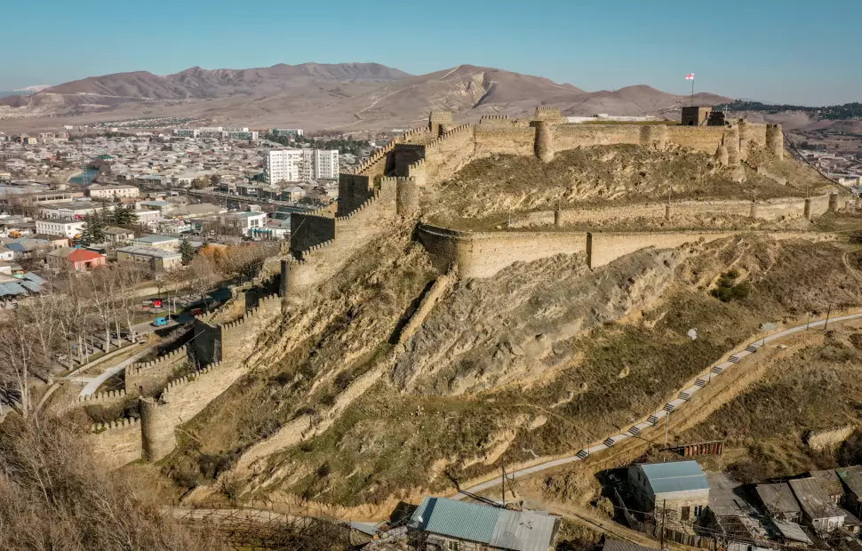 Panoramic view of the medieval Gori Fortress ruins set against a backdrop of Georgian mountain landscapes