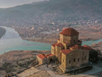 View of the historic Jvari Monastery stone building nestled in the Georgian landscape