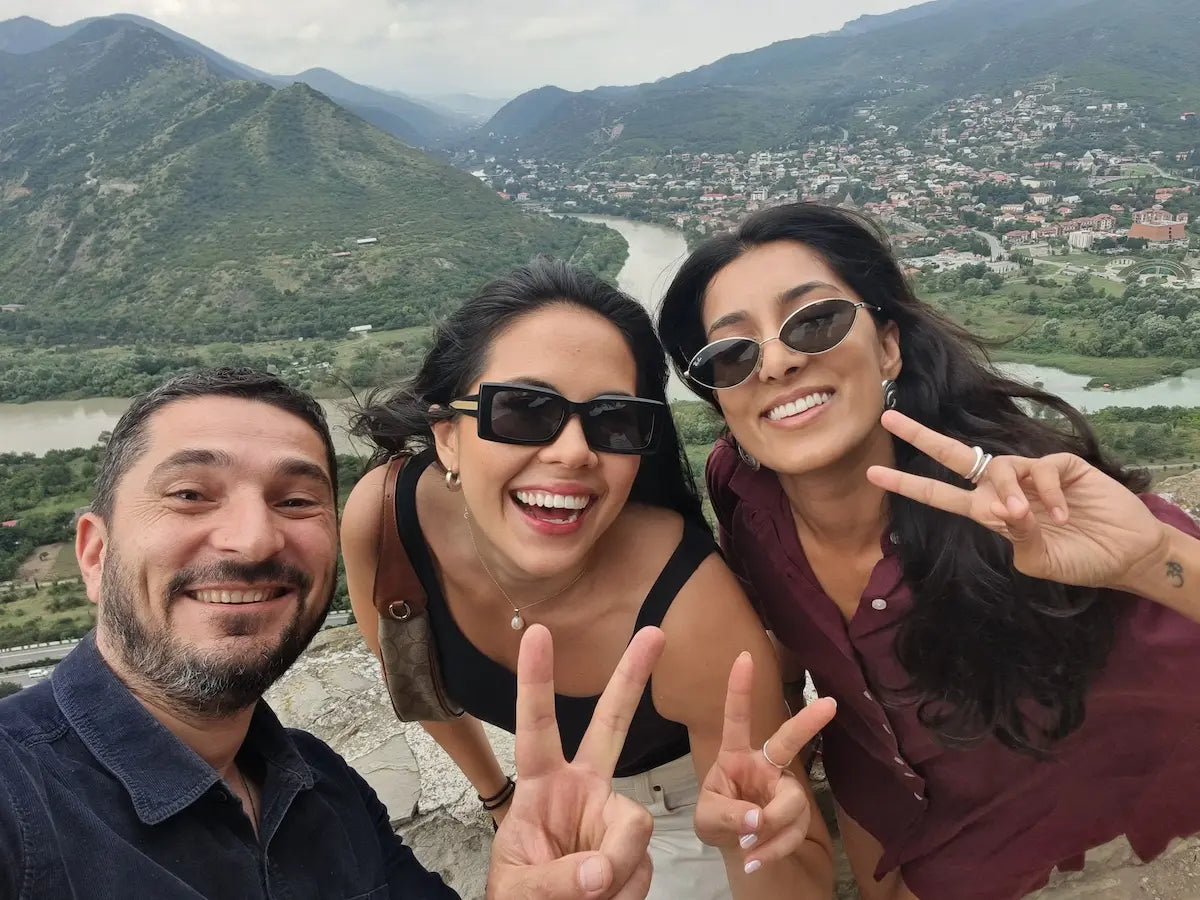 Happy travelers from London taking a selfie with the stunning landscape view from Jvari Monastery.
