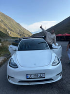 Private English-speaking driver and guide with a Tesla electric car for tours in the Georgian Caucasus mountains.